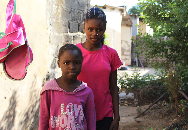 Sandra and Faith outside their one-room home in a compound in Zambia.